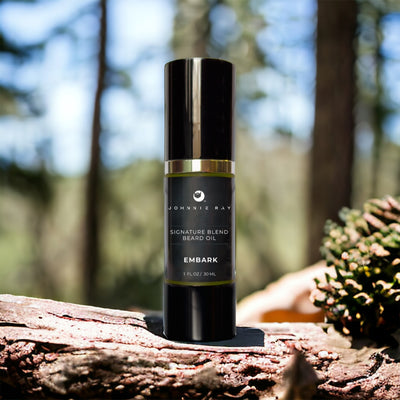 Johnnie Ray Signature Blend Beard Oil in a black airless pump top bottle on a log in a cypress woods. 