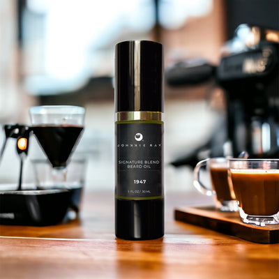 Johnnie Ray Signature Blend Beard Oil in a black airless pump top bottle on a wooden counter in front of espresso shots. 