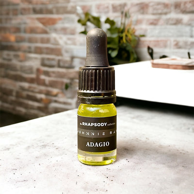 5mL bottle of The Rhapsody Collection Adagio Signature Blend Beard Oil from Johnnie Ray sitting on a concrete countertop