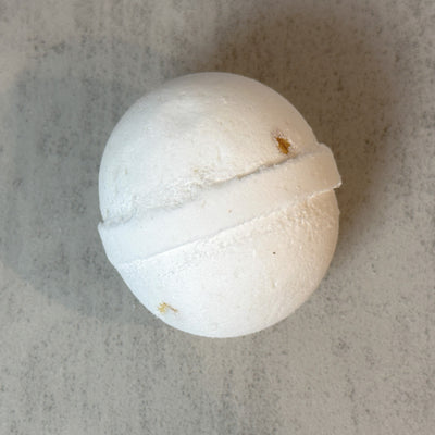 White Johnnie Ray Oatmeal and Honey bath bomb against concrete background.