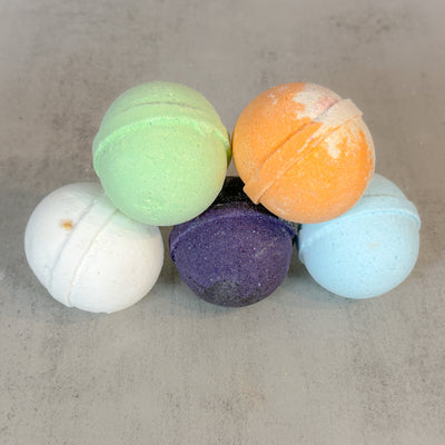5 colorful bath bombs stacked in a pyramid formation.