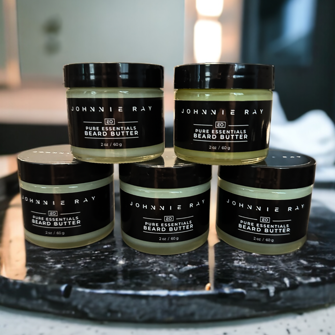 5 jars of Johnnie Ray Pure Essentials Beard Butter stacked on black marble counter