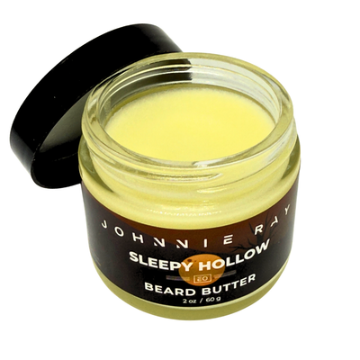 Open jar of Johnnie Ray Sleepy Hollow beard butter on a white background