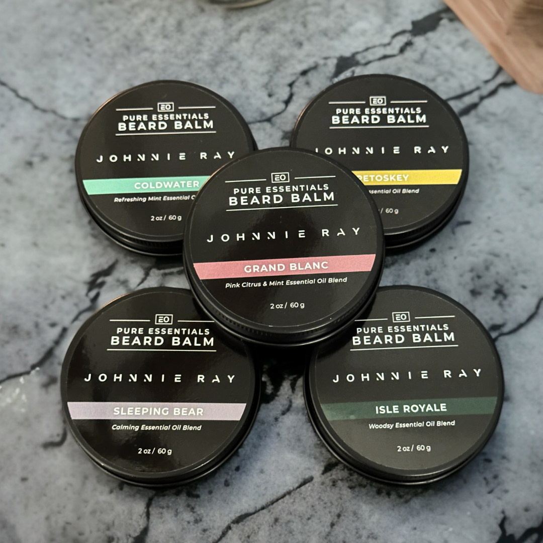 5 tins of Johnnie Ray Pure Essentials Beard Balm stacked on black marble counter