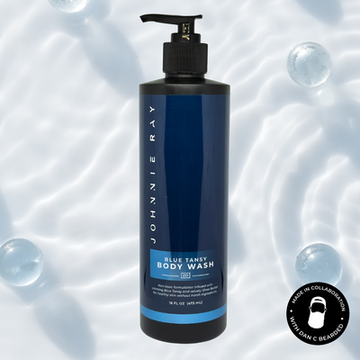 Johnnie Ray Blue Tansy Body Wash bottle on a background with bubbles