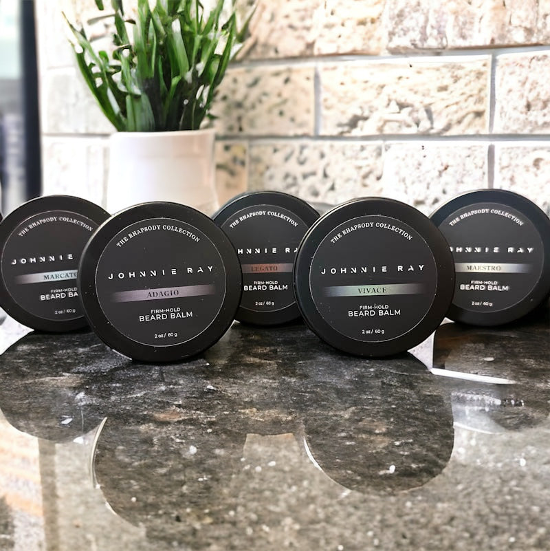 Johnnie Ray Beard Balms from The Rhapsody Collection in a black tin displayed on black granite counters