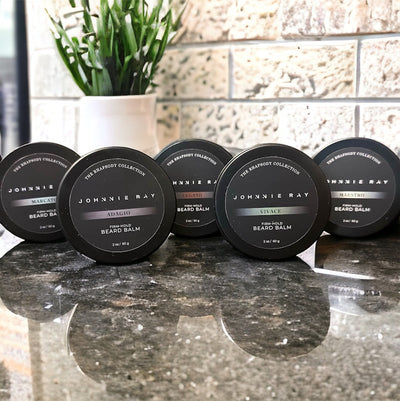 Johnnie Ray Beard Balms from The Rhapsody Collection in a black tin displayed on black granite counters