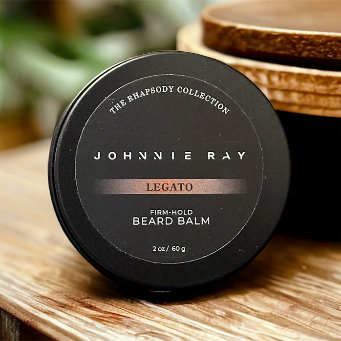 Johnnie Ray Legato Beard Balm from The Rhapsody Collection in a black tin displayed on rustic wood vanity