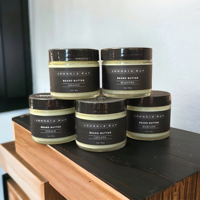 Five Johnnie Ray Beard Butters from The Rhapsody Collection sitting on a dark wood countertop