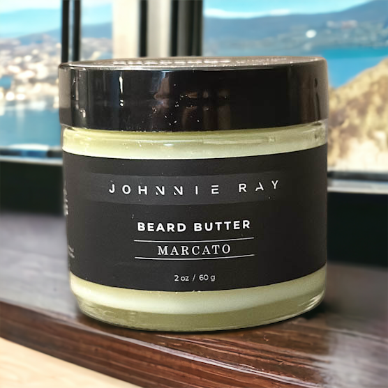 Johnnie Ray Marcato Beard Butter from The Rhapsody Collection sitting on a wood ledge overlooking the coast