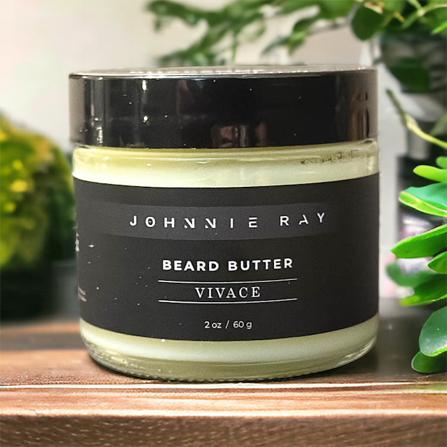 Johnnie Ray Vivace Beard Butter from The Rhapsody Collection sitting on a wood surface with green plants