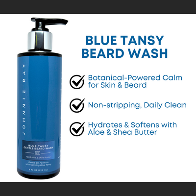 Black bottle of Johnnie Ray Blue Tansy Beard Wash with a blue label with text "Blue Tansy Beard Wash: Botanical-Powered Calm for Skin & Beard, Non=stripping Daily Clean, and Hydrates & Softens with Aloe & Shea Butter"