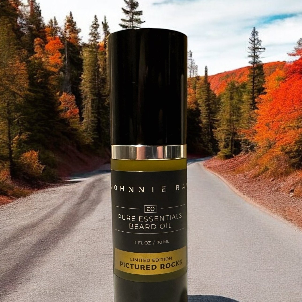 Johnnie Ray Pictured Rocks Beard Oil bottle close up view on a dirt road and fall foliage