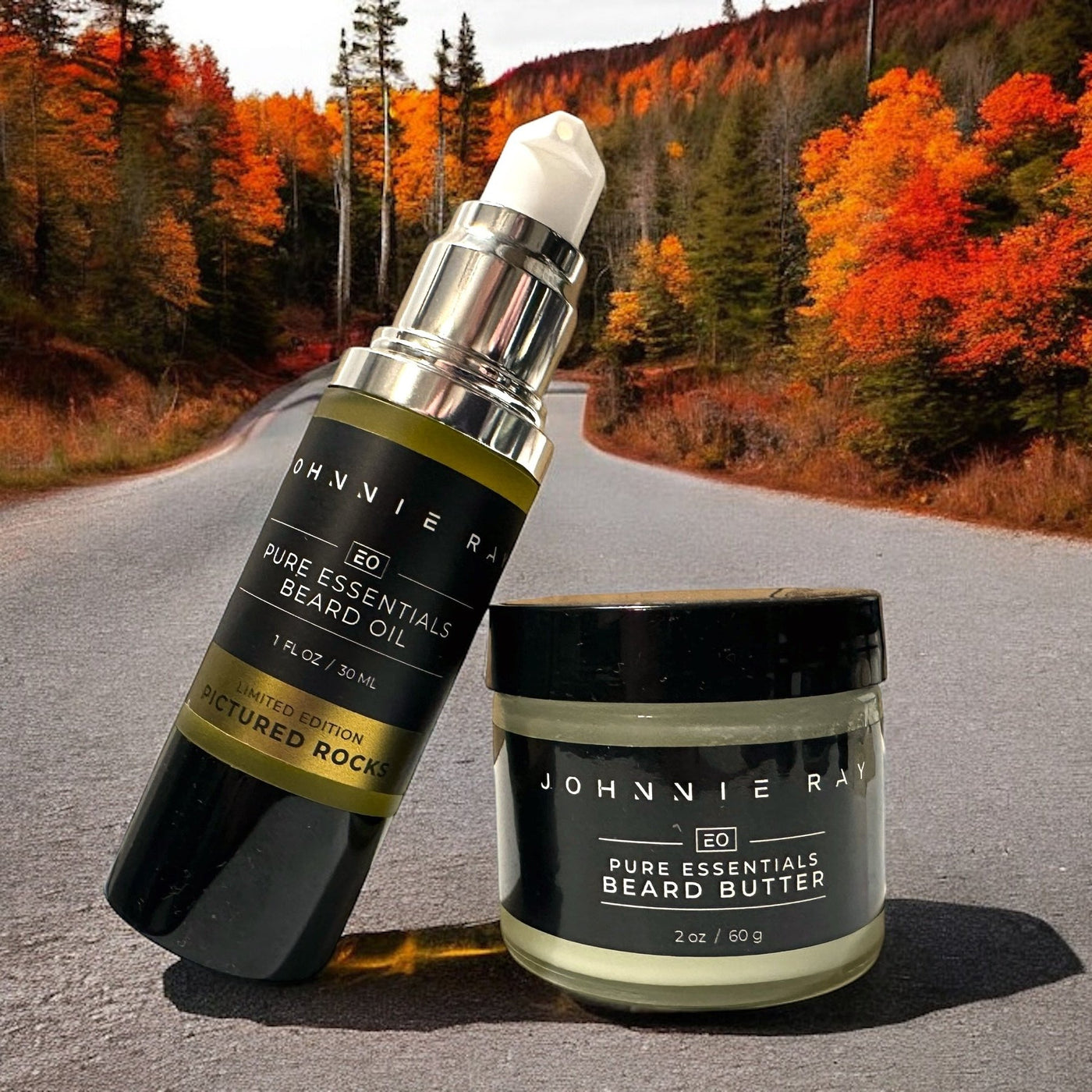 Johnnie Ray Pictured Rocks Beard Oil Bottled leaned against a jar of Pictured Rocks Beard Butter on a dirt road with fall foliage in background