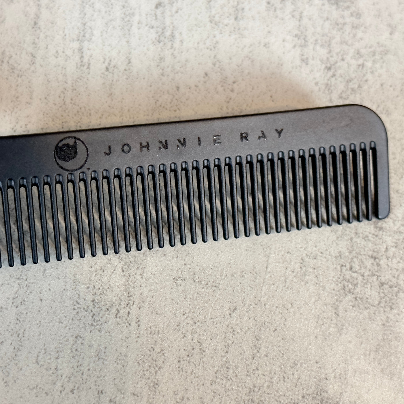 Black Chicago Comb Model 1 angled to show Johnnie Ray logo engraving across the top/